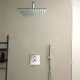 Duschkopf von Ideal Standard mit quadratischer Oberfläche und einer Handbrause daneben. Thermostatsteuerung an der Wand, in einem modernen Badezimmer-Setting.